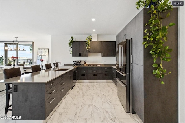 7180 E Kierland Blvd Unit 916, Scottsdale, AZ 85254 - kitchen with a sink, light marble finish floors, high end fridge, a breakfast bar area, and a peninsula