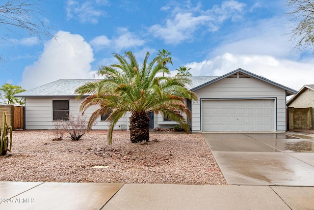 single story home featuring driveway, a garage, and fence