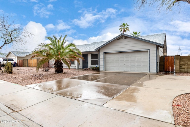 single story home featuring roof with shingles, concrete driveway, a gate, fence, and a garage