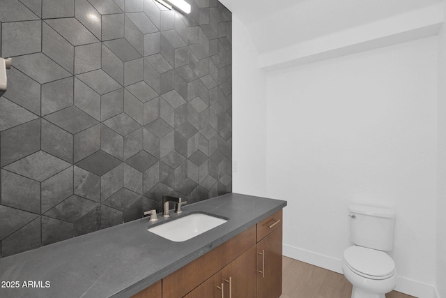 bathroom with toilet, vanity, and hardwood / wood-style flooring