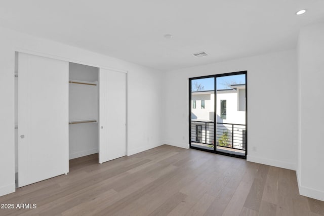 unfurnished bedroom with a closet and light hardwood / wood-style floors