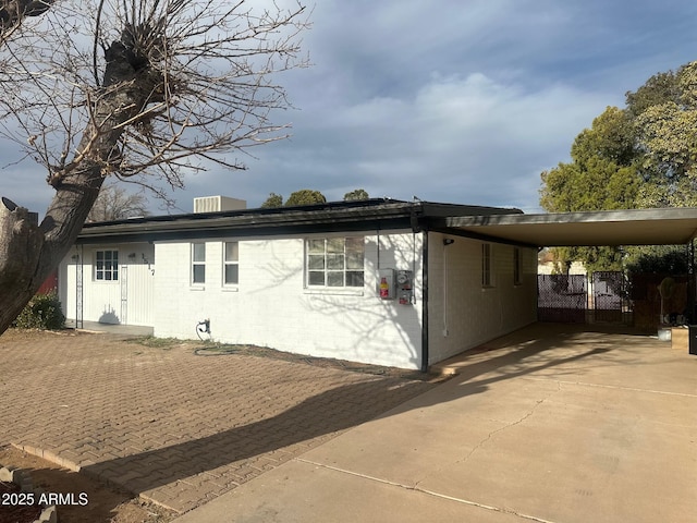 exterior space featuring fence, an attached carport, and concrete driveway