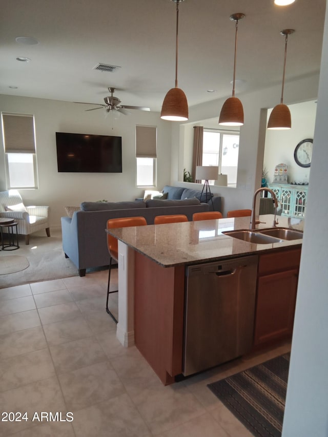 kitchen with dishwasher, sink, decorative light fixtures, light stone counters, and ceiling fan