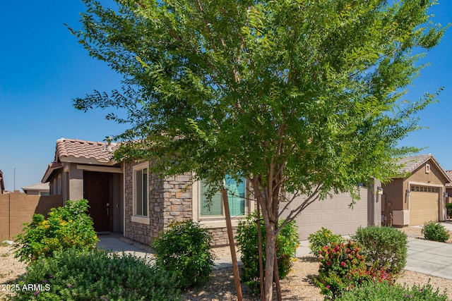 3815 S 64th Ln, Phoenix, AZ 85043 - view of front facade with stucco siding, a tiled roof, a garage, and stone siding