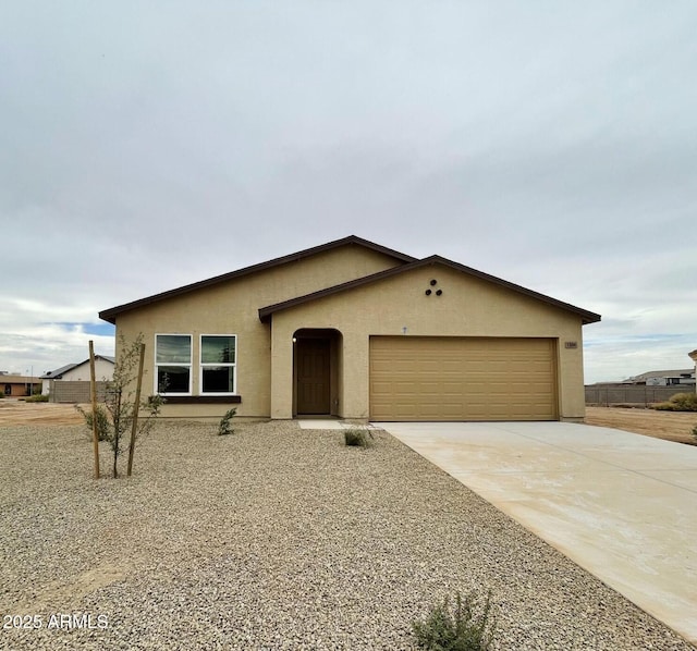 view of front of house featuring an attached garage, concrete driveway, and stucco siding