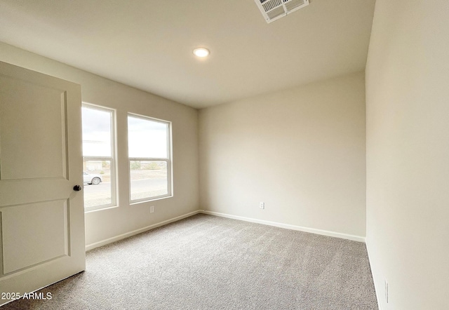 carpeted empty room featuring visible vents and baseboards