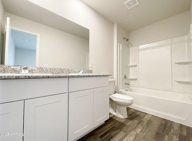 full bathroom with bathtub / shower combination, visible vents, a sink, and wood finished floors