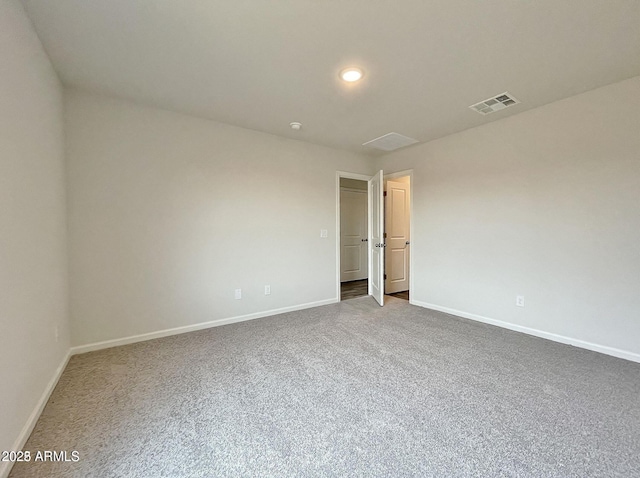 carpeted spare room featuring visible vents and baseboards