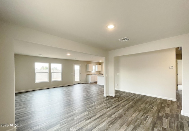 unfurnished living room with recessed lighting, dark wood-style flooring, visible vents, and baseboards