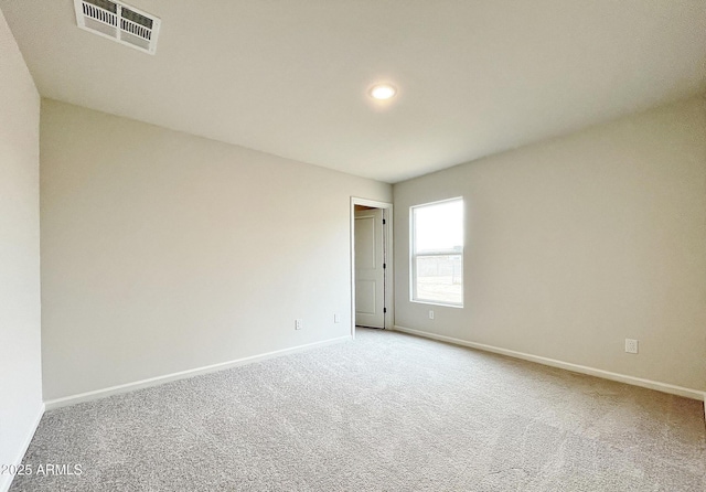 spare room featuring baseboards, visible vents, and carpet flooring