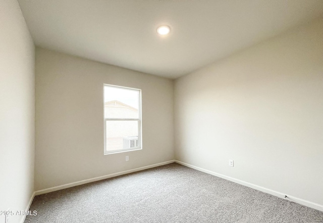 carpeted spare room featuring baseboards