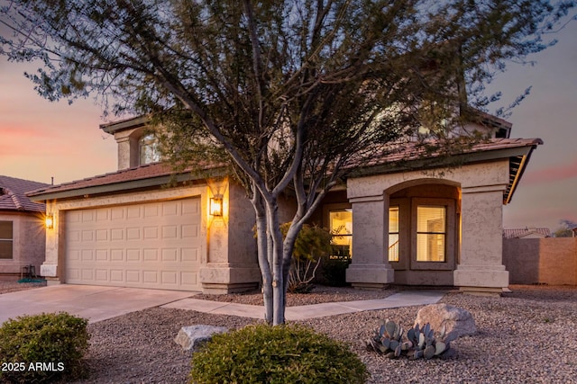 view of front facade featuring driveway, an attached garage, and stucco siding