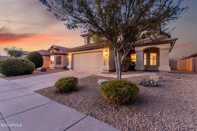 view of front of house featuring driveway, fence, and stucco siding