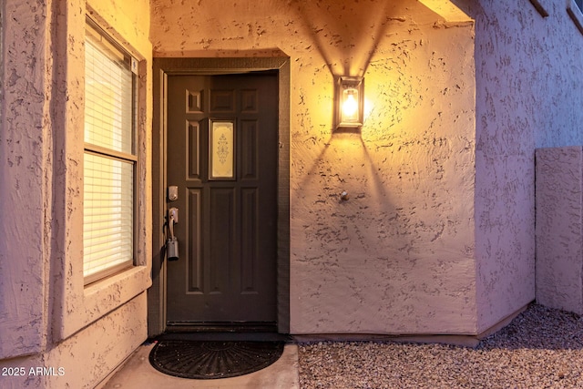 entrance to property with stucco siding