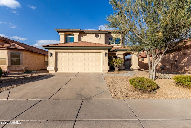 mediterranean / spanish-style house with a garage, a tiled roof, concrete driveway, and stucco siding