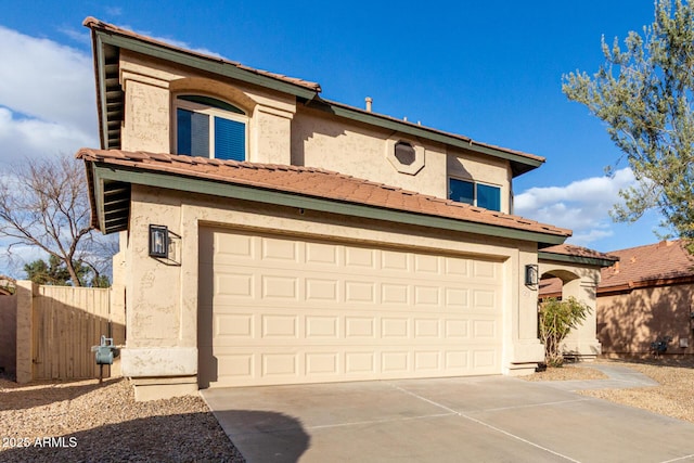 mediterranean / spanish-style house with driveway, an attached garage, a tile roof, and stucco siding