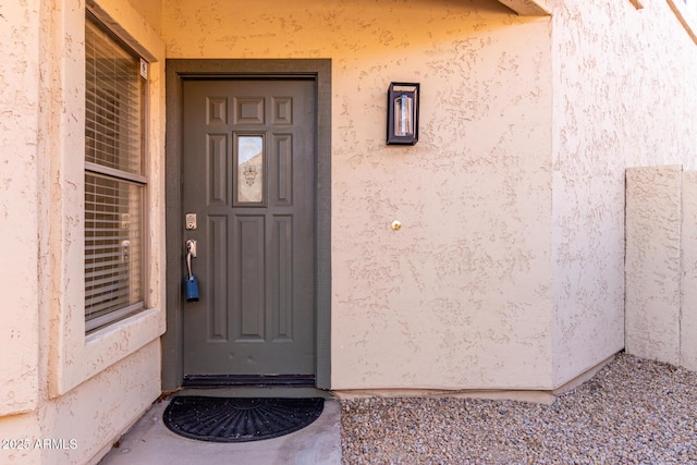 entrance to property featuring stucco siding