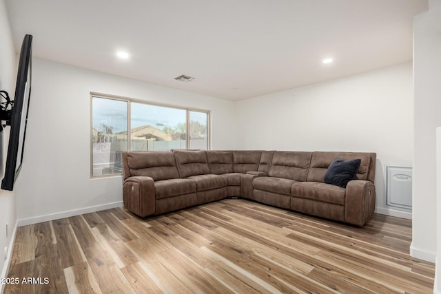 living area with light wood-style flooring, visible vents, baseboards, and recessed lighting