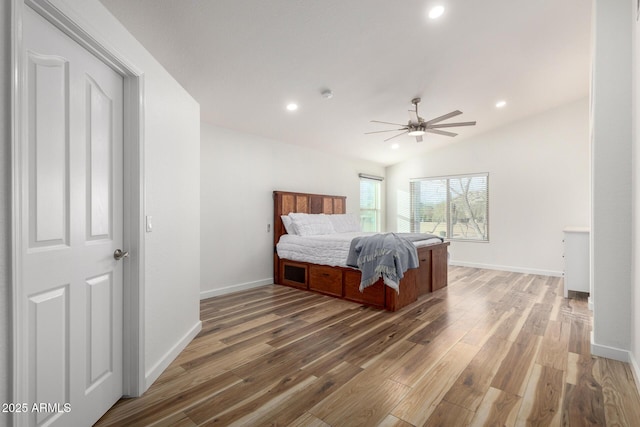 bedroom with light wood-style flooring, baseboards, vaulted ceiling, and recessed lighting