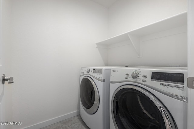 laundry room featuring washing machine and dryer, laundry area, baseboards, and light tile patterned floors