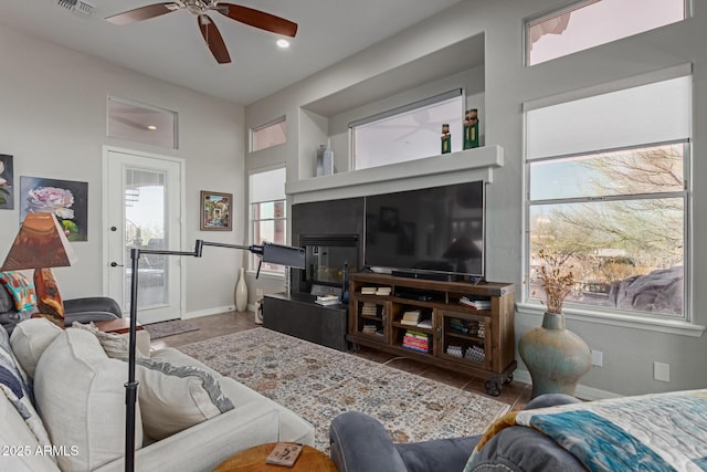 tiled living room featuring ceiling fan and a wealth of natural light