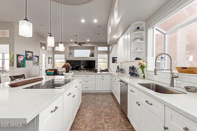 kitchen with sink, white cabinetry, black electric cooktop, stainless steel dishwasher, and light stone countertops