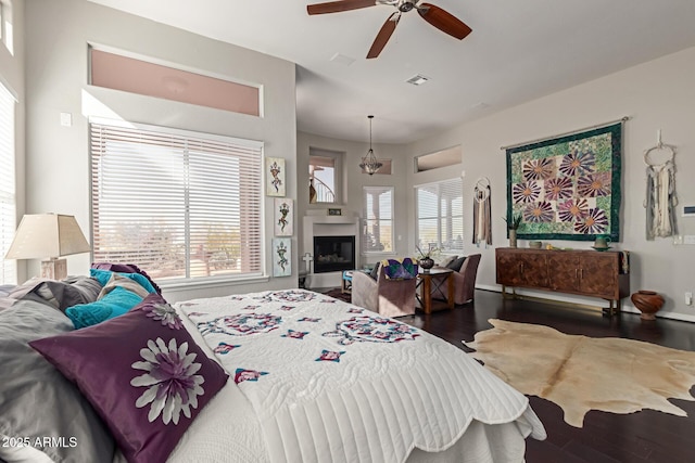 bedroom with dark wood-type flooring, ceiling fan, and multiple windows