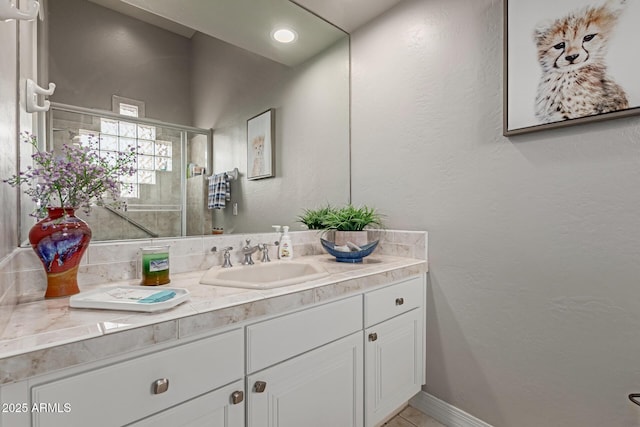 bathroom with vanity and a shower with door