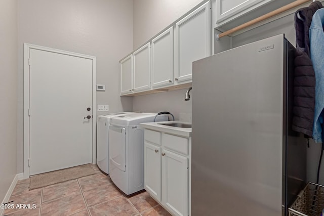 laundry room with cabinets, light tile patterned floors, and washing machine and clothes dryer