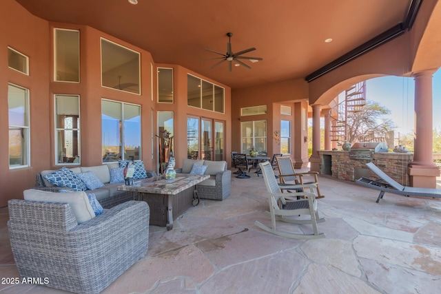 view of patio / terrace featuring area for grilling, an outdoor living space, ceiling fan, and an outdoor kitchen