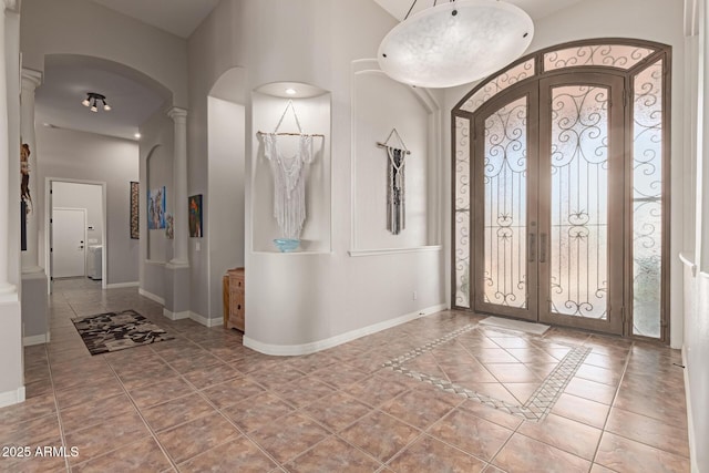 tiled foyer with decorative columns and french doors