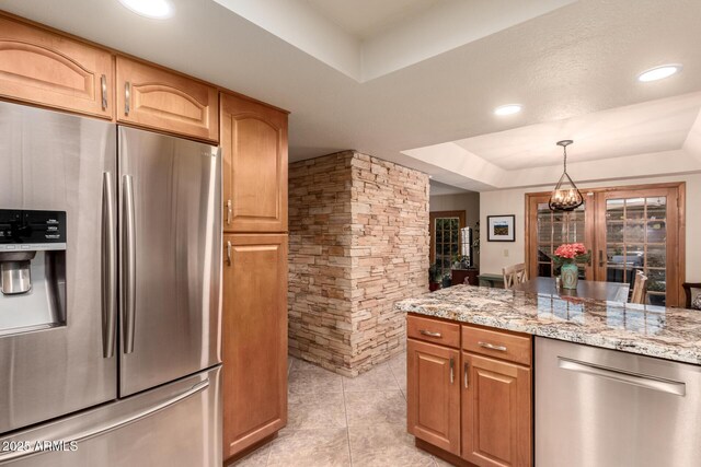 kitchen with pendant lighting, light tile patterned floors, a tray ceiling, a notable chandelier, and stainless steel appliances