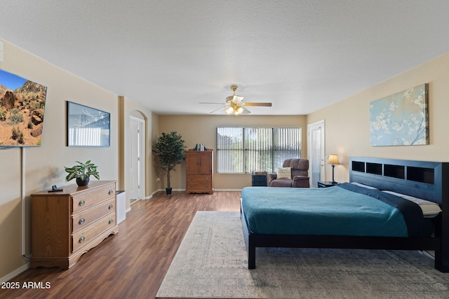 bedroom featuring a ceiling fan, baseboards, and wood finished floors