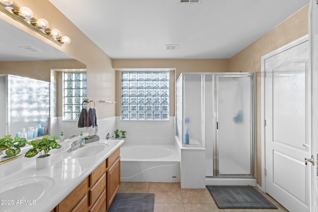 full bath with a stall shower, tile patterned flooring, a garden tub, and a sink