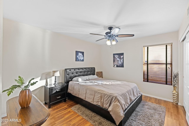 bedroom featuring ceiling fan, baseboards, and wood finished floors