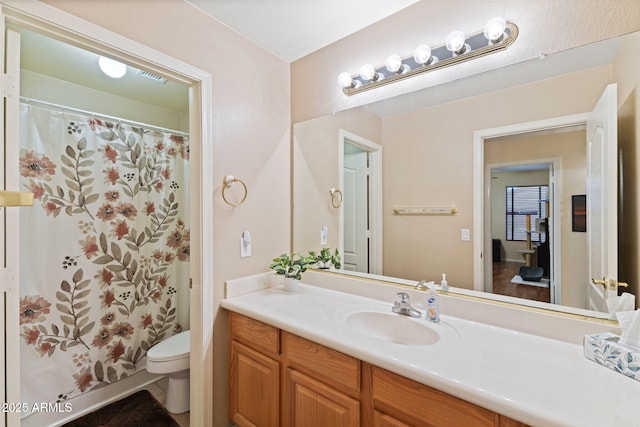 bathroom with toilet, a shower with shower curtain, and vanity