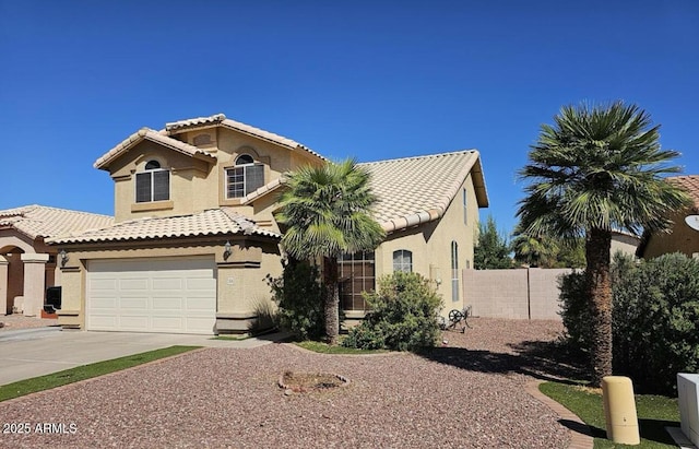 mediterranean / spanish home featuring stucco siding, concrete driveway, fence, a garage, and a tiled roof