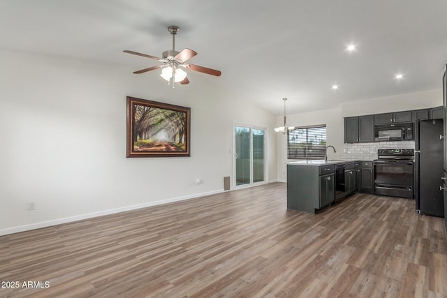 1047 W Laguna Dr, Tempe, AZ 85282 - kitchen with black appliances, a sink, a peninsula, baseboards, and a chandelier