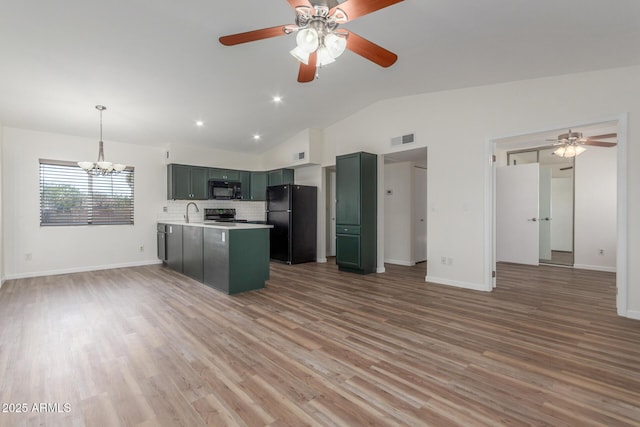 1047 W Laguna Dr, Tempe, AZ 85282 - kitchen with black appliances, vaulted ceiling, open floor plan, light countertops, and a chandelier