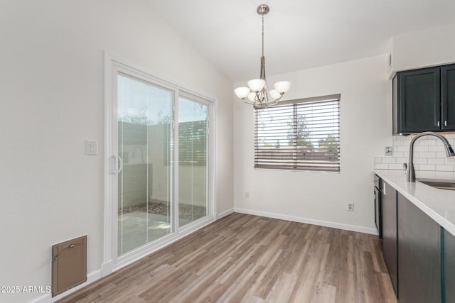 1047 W Laguna Dr, Tempe, AZ 85282 - unfurnished dining area featuring a sink, plenty of natural light, a chandelier, light wood-style floors, and lofted ceiling