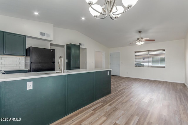 1047 W Laguna Dr, Tempe, AZ 85282 - kitchen featuring freestanding refrigerator, lofted ceiling, a sink, light countertops, and decorative backsplash