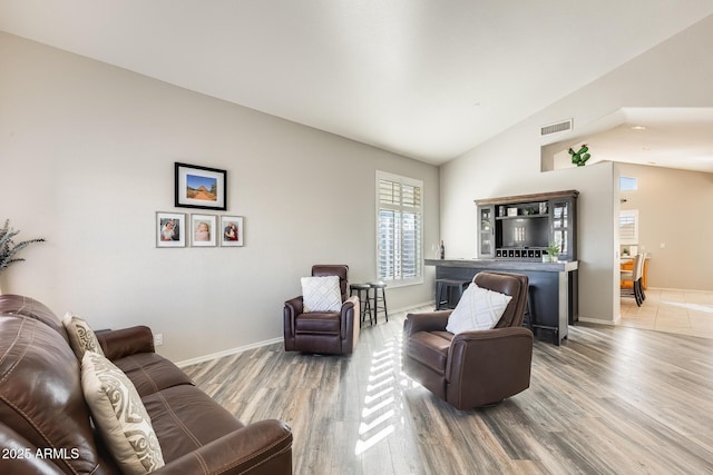 living room with hardwood / wood-style floors and vaulted ceiling