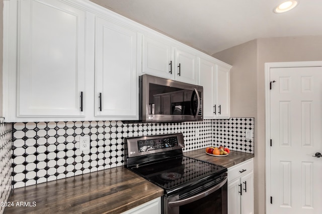 kitchen with tasteful backsplash, black electric range, white cabinets, and breakfast area