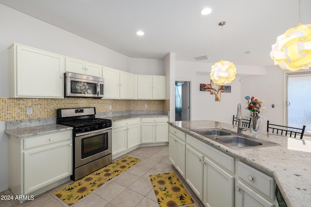 kitchen with stainless steel appliances, visible vents, hanging light fixtures, backsplash, and a sink