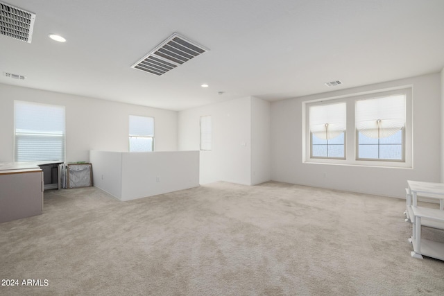 empty room featuring visible vents and light colored carpet