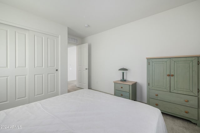 bedroom with a closet and light colored carpet