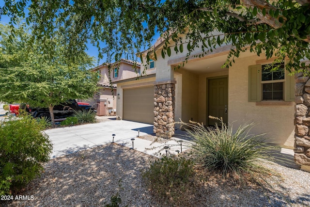 view of front of house featuring a garage, concrete driveway, and stucco siding