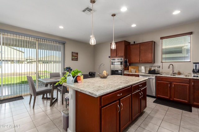 kitchen with hanging light fixtures, light tile patterned floors, sink, a kitchen island, and appliances with stainless steel finishes