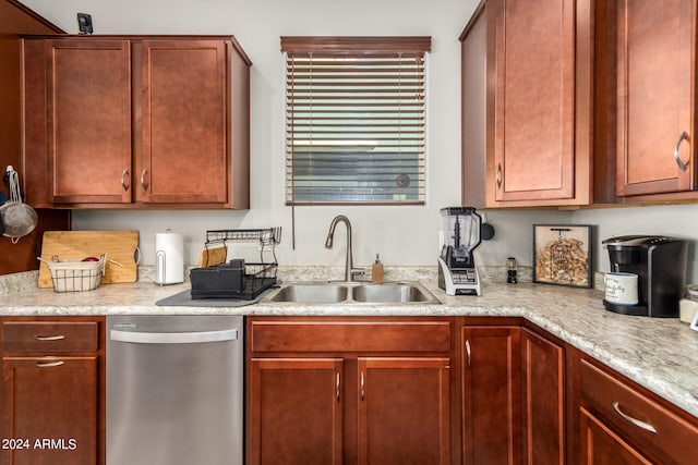 kitchen featuring light stone countertops, dishwasher, and sink