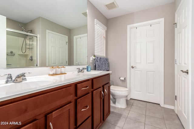 bathroom featuring vanity, a shower with shower door, toilet, and tile patterned floors